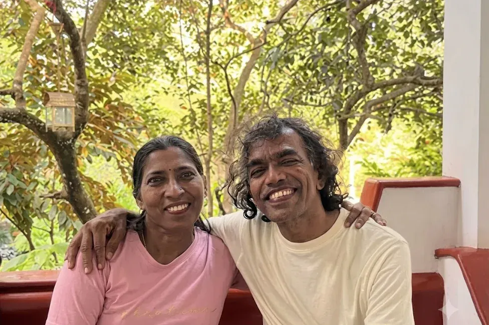 Ayurtheeram founders Anitha and Ramesh smiling together on a veranda among trees
