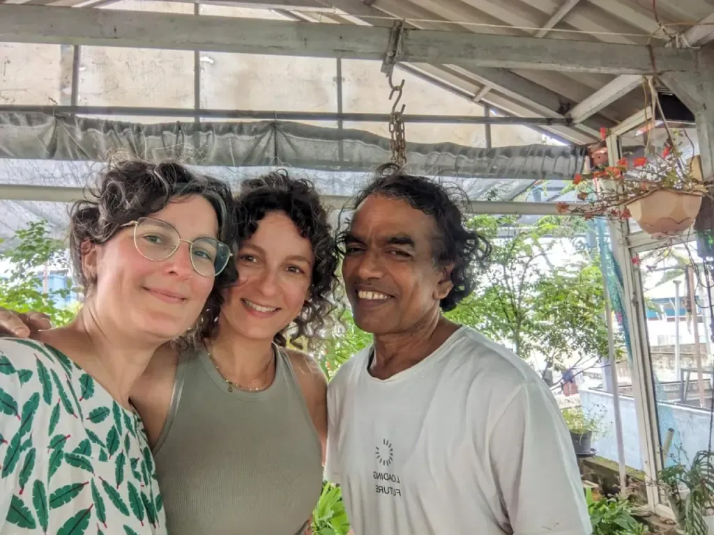 Two guests taking a selfie with their teacher under the shala roof