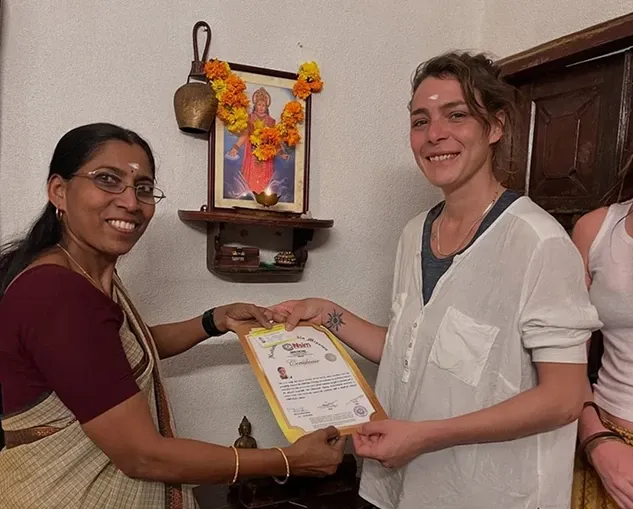 A student receiving a yoga course certificate at Ayurtheeram
