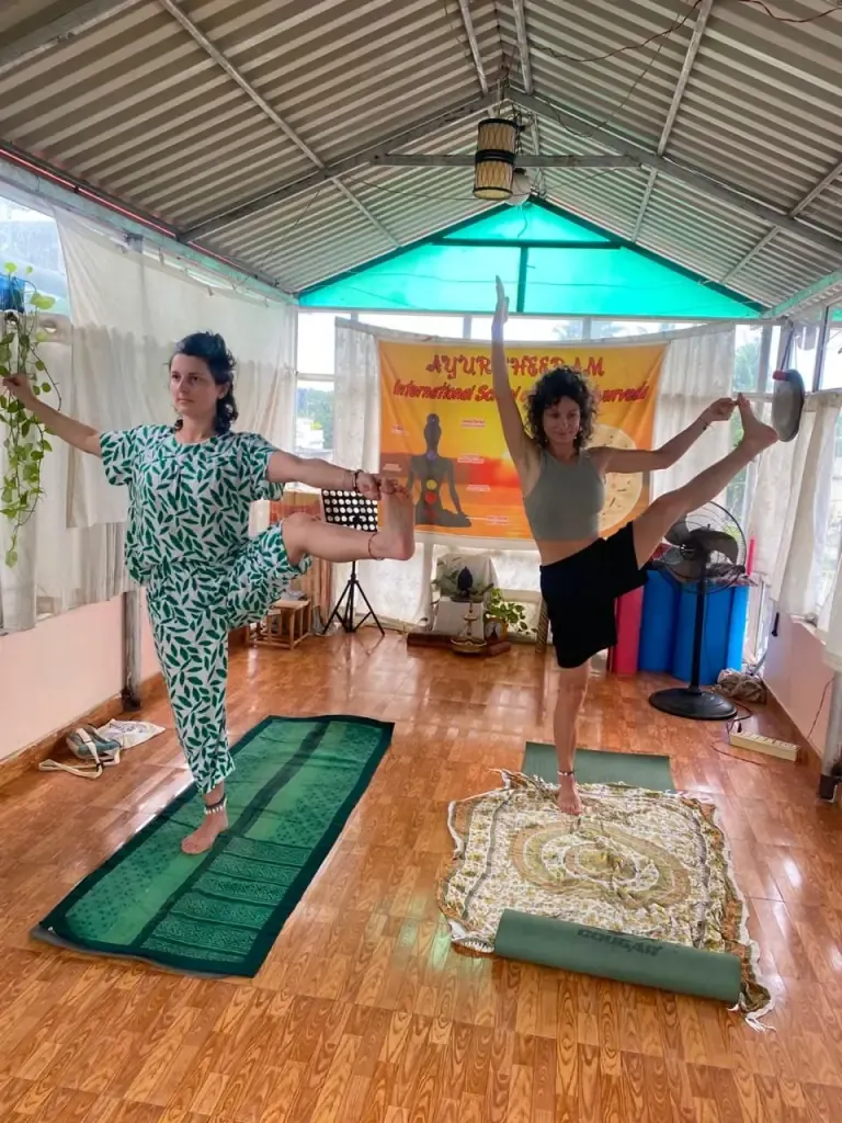 Two guests balancing in dancer pose in the Ayurtheeram yoga shala