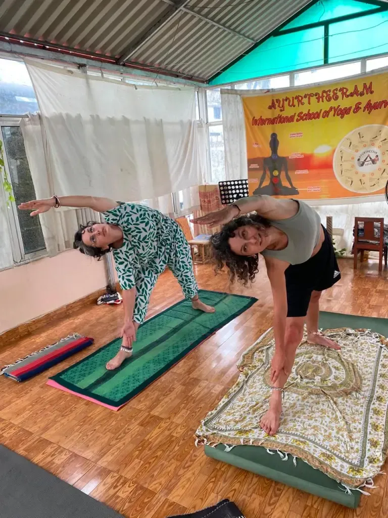 Two guests stretching into triangle pose side by side
