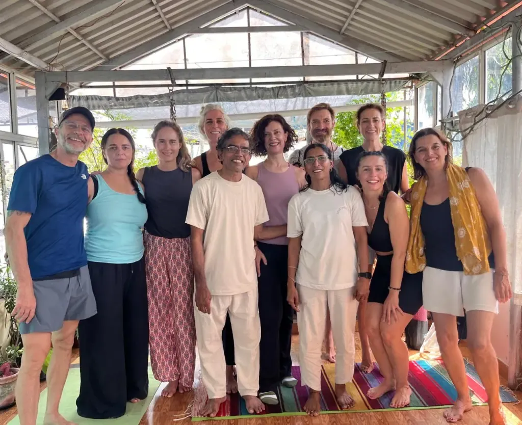 A yoga course group portrait with teachers and guests in the shala